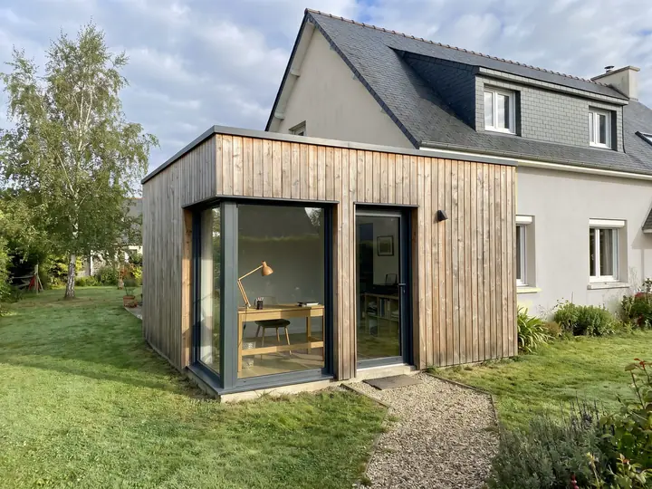 Illustration : extension de plain-pied à bardage bois aménagée en bureau, vue depuis le jardin